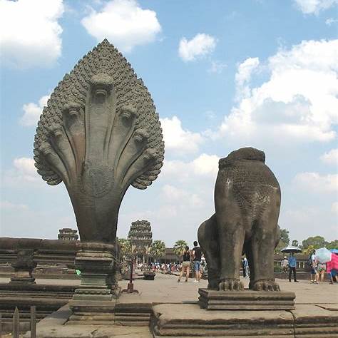 Nāga / Neak balustrade at Angkor Wat, Cambodia — the multi-headed serpent stands at monumental scale beside the elephant, one of the great living symbols of strength and power in Khmer culture. Its greater size marks the nāga as more than an animal image: a threshold guardian, water-being, protector, ancestral force, and sacred presence at the entrance to holy space.